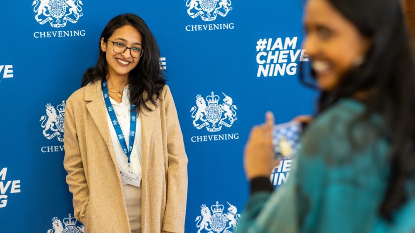 Scholar stood in front of Chevening media board
