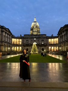 Alumna holding graduation scroll
