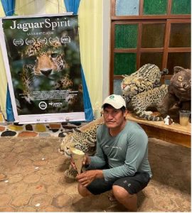 Man posing in front of film poster with popcorn