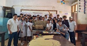 Participants smile at the camera holding up a jaguar poster