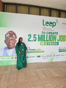 Elizabeth standing in front of a large poster promoting LEEP.