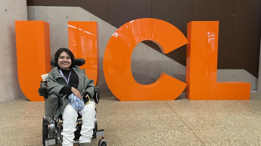 Kavya in front of a 'UCL' sign