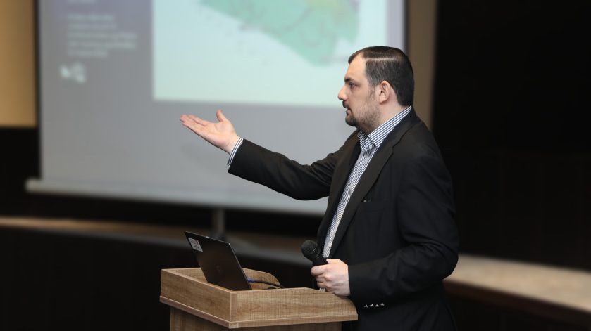 Alumnus presenting at lecturn.